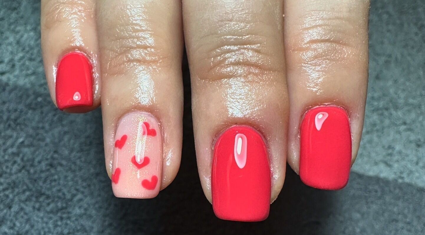 Red polished nails with heart designs at Sage beauty & aesthetics, Wigan, England, GB.