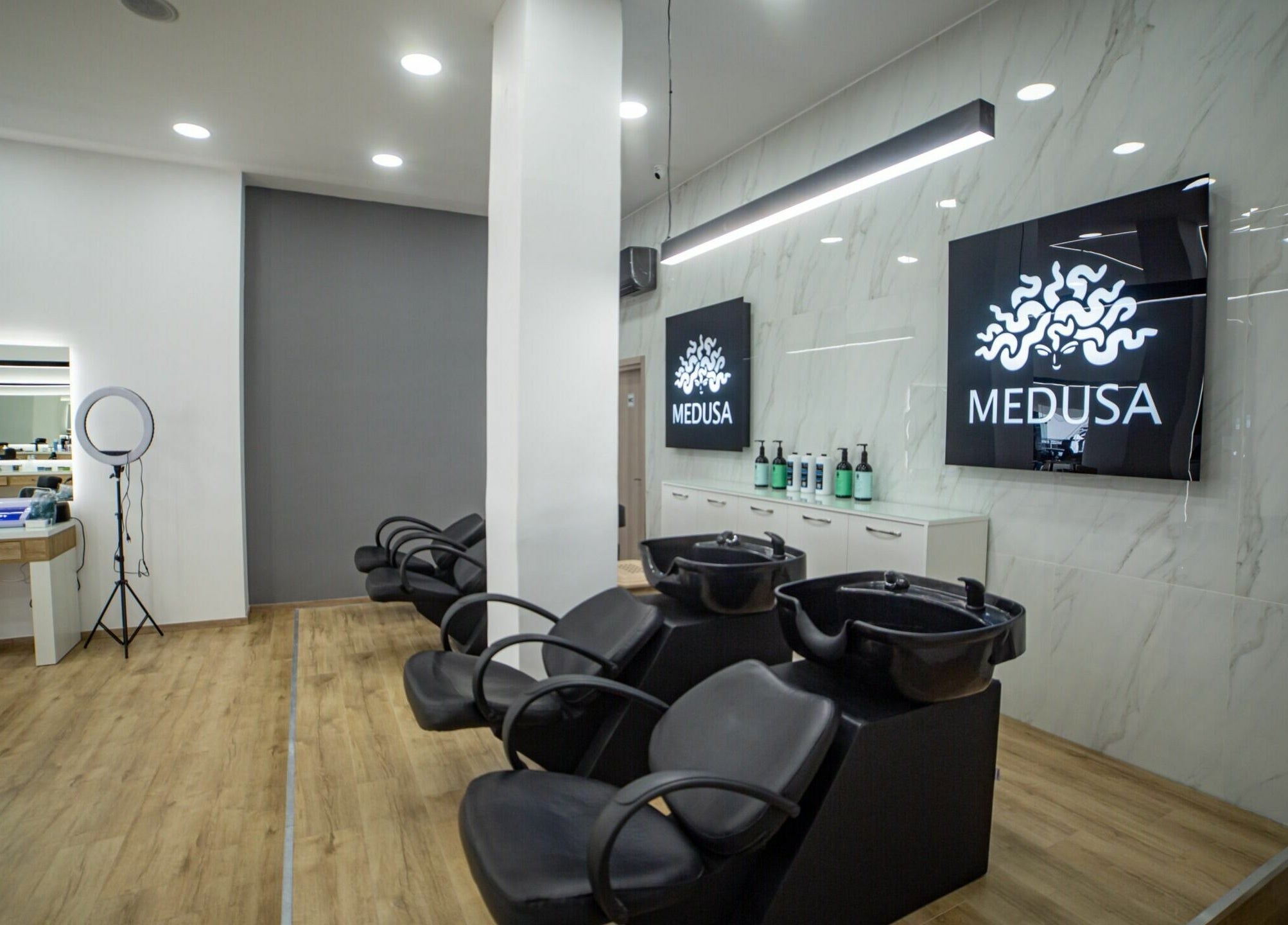Εσωτερικό κομμωτηρίου Medusa Kordelio στο Ελευθέριο Κορδελιό, GR με μοντέρνα διακόσμηση και κομμωτήρια καθίσματα.