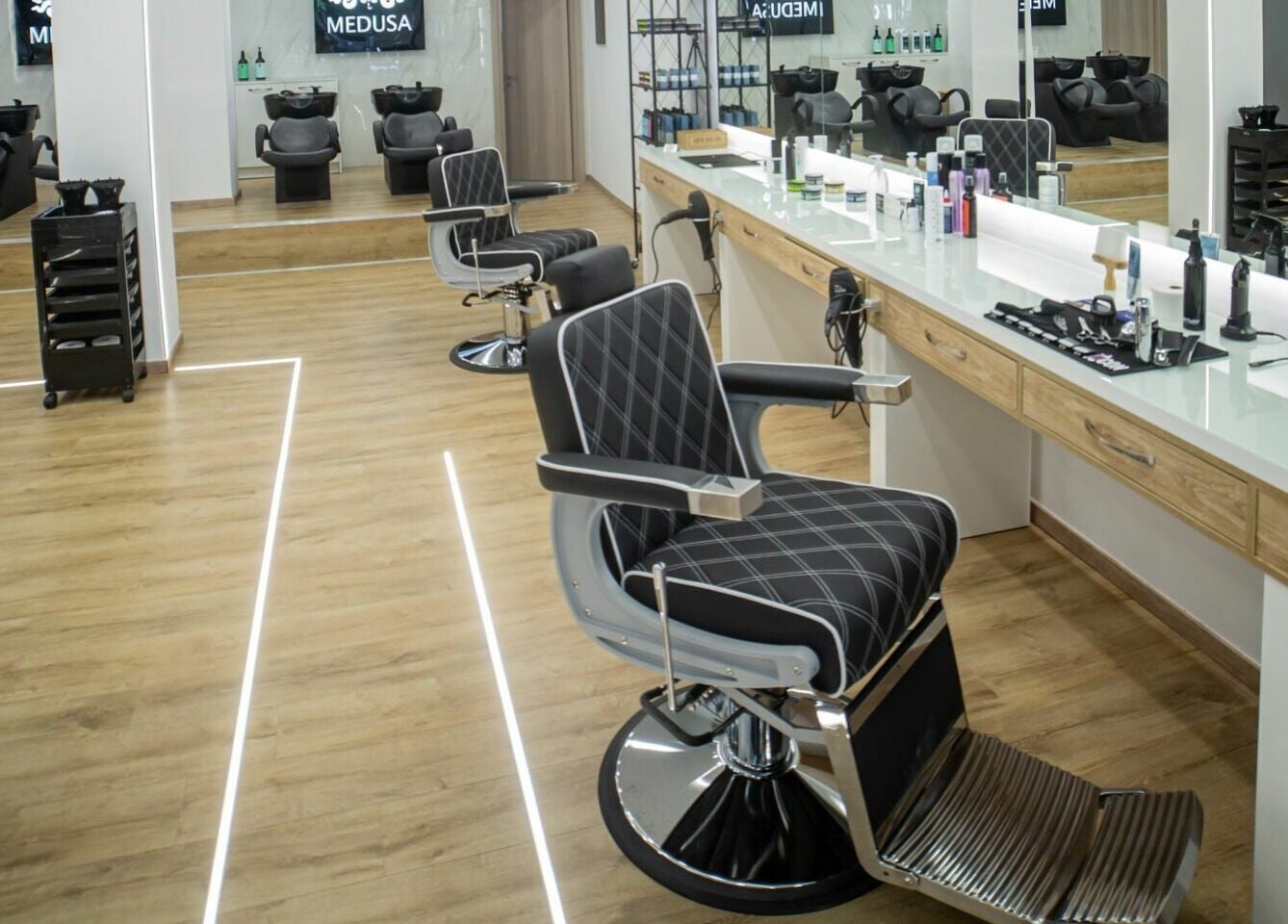 Καλαίσθητος χώρος κομμωτηρίου στο Medusa Kordelio, Ελευθέριο Κορδελιό, GR με πολυτελή καθίσματα και καθρέφτες.
