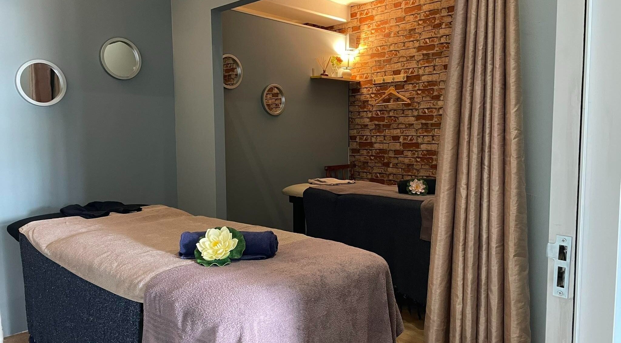 Relaxing massage room at JMS Wellness Durbanville, Cape Town, Western Cape, ZA featuring cozy beds and soft lighting.