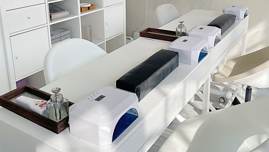 Modern nail bar setup at Soso Beauty, Liverpool, England, GB. Elegant white design with nail dryers.