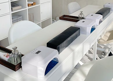 Modern nail bar setup at Soso Beauty, Liverpool, England, GB. Elegant white design with nail dryers.