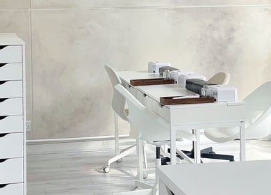 Elegant nail desk setup at Soso Beauty, Liverpool, England, GB, featuring modern white decor and storage.