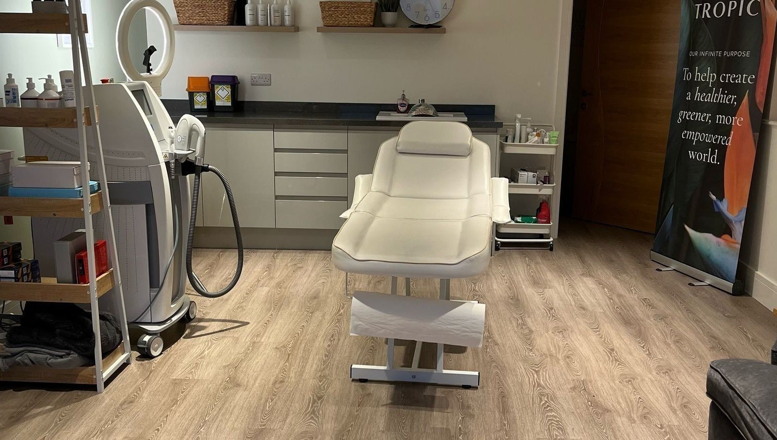 Treatment room at Glow Aesthetics in Stretcholt, England, GB with a modern spa bed and beauty equipment.