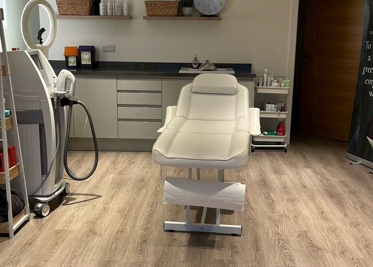 Treatment room at Glow Aesthetics in Stretcholt, England, GB with a modern spa bed and beauty equipment.