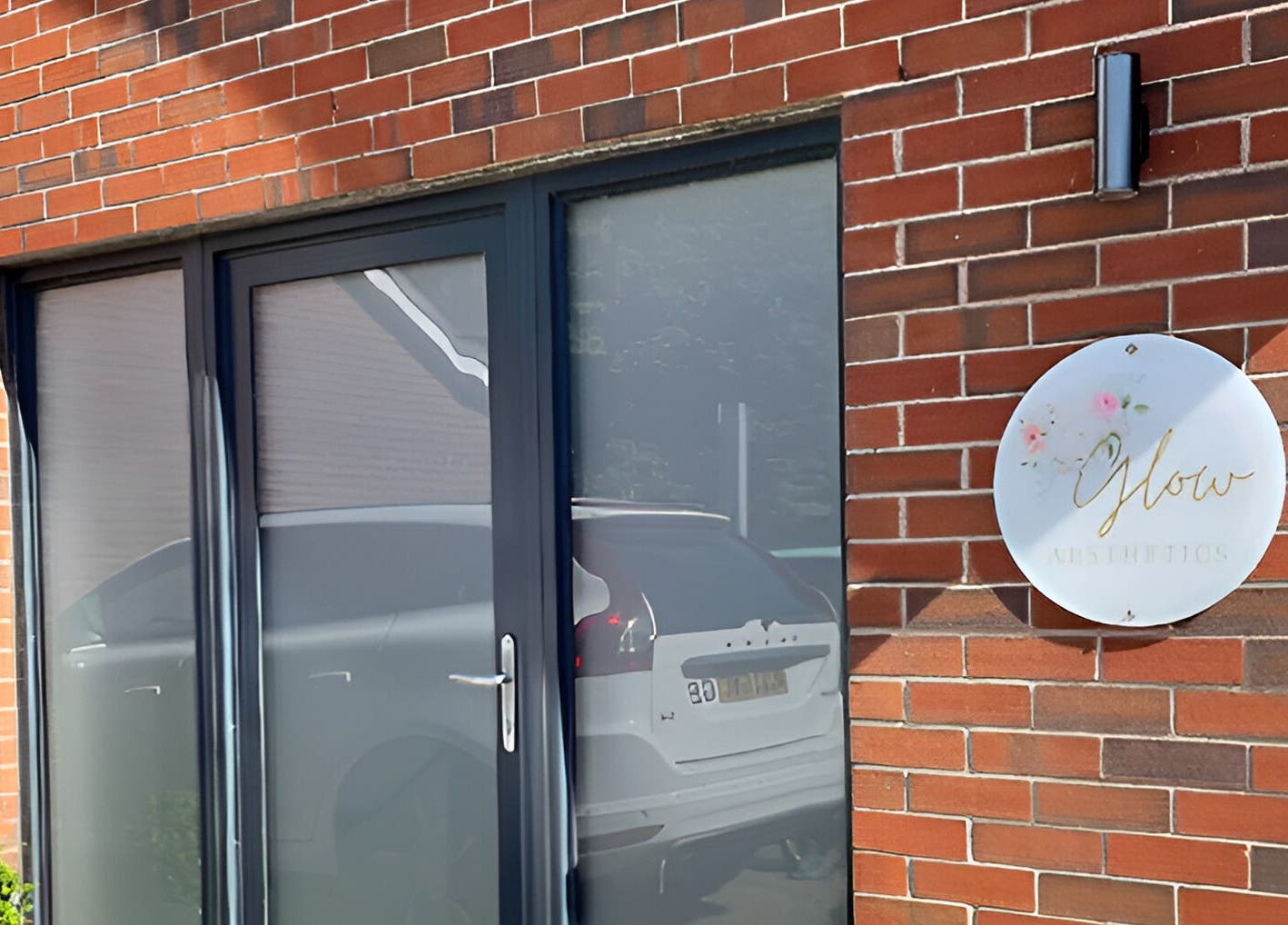 Front entrance of Glow Aesthetics, showcasing signage and brick design in Stretcholt, England, GB.