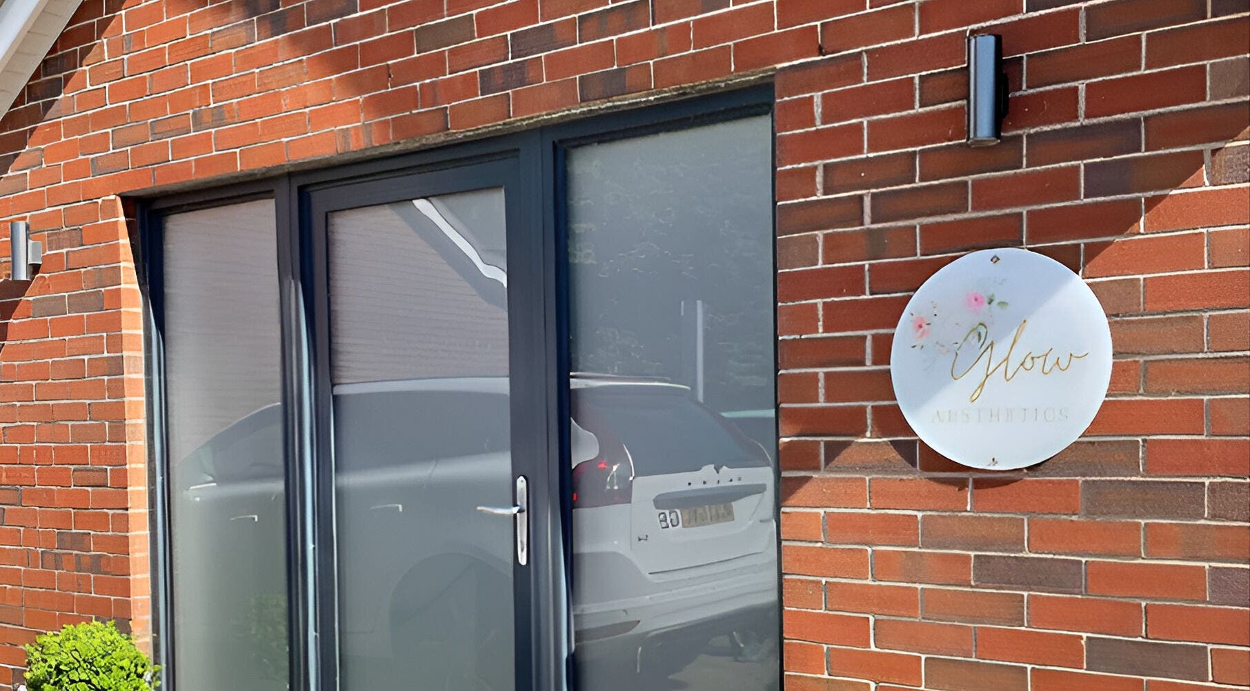 Front entrance of Glow Aesthetics, showcasing signage and brick design in Stretcholt, England, GB.