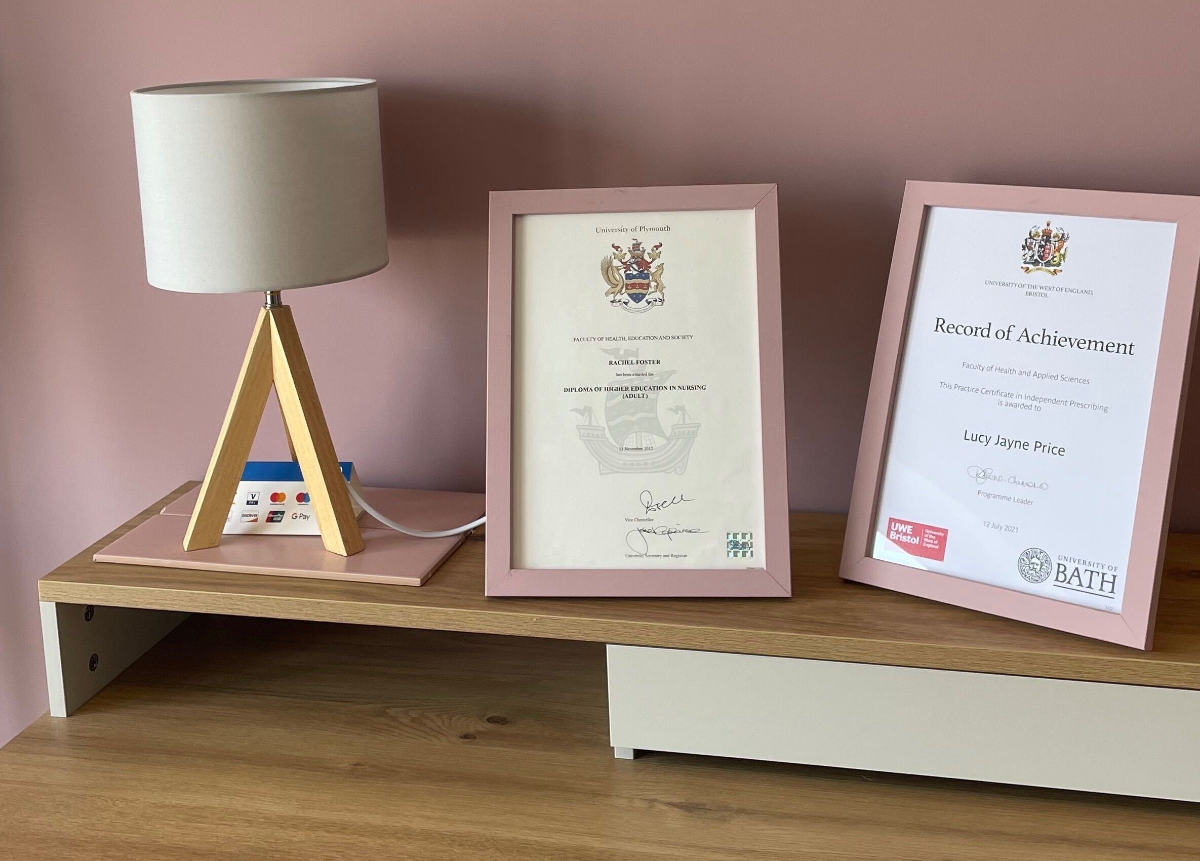 Certificates on a wooden shelf at Glow Aesthetics, Stretcholt, England, GB, showcasing professionalism.