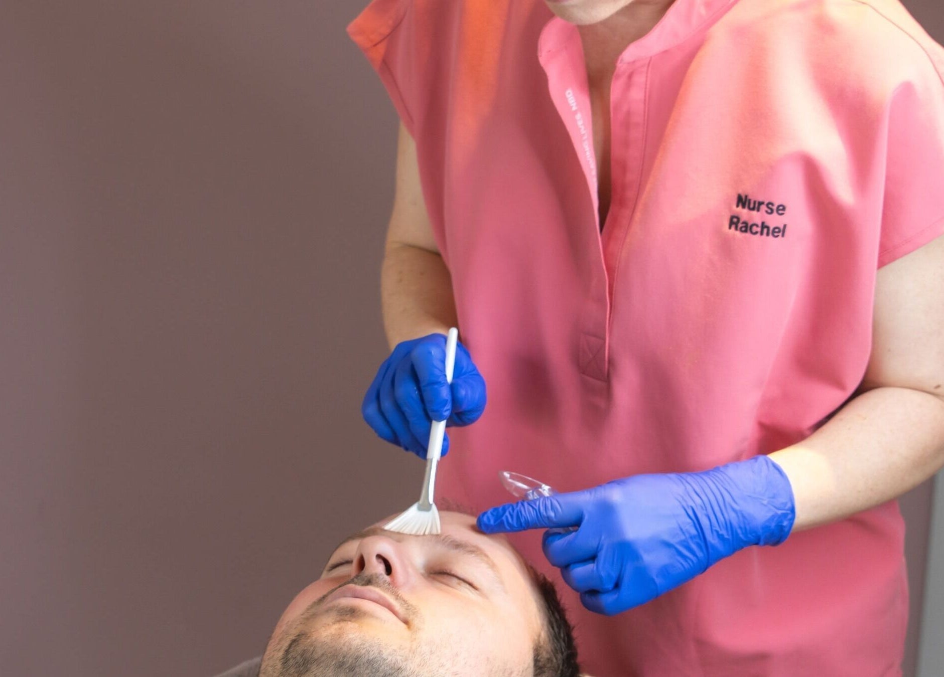 Skilled aesthetician applies facial treatment at Glow Aesthetics, Stretcholt, England, GB.