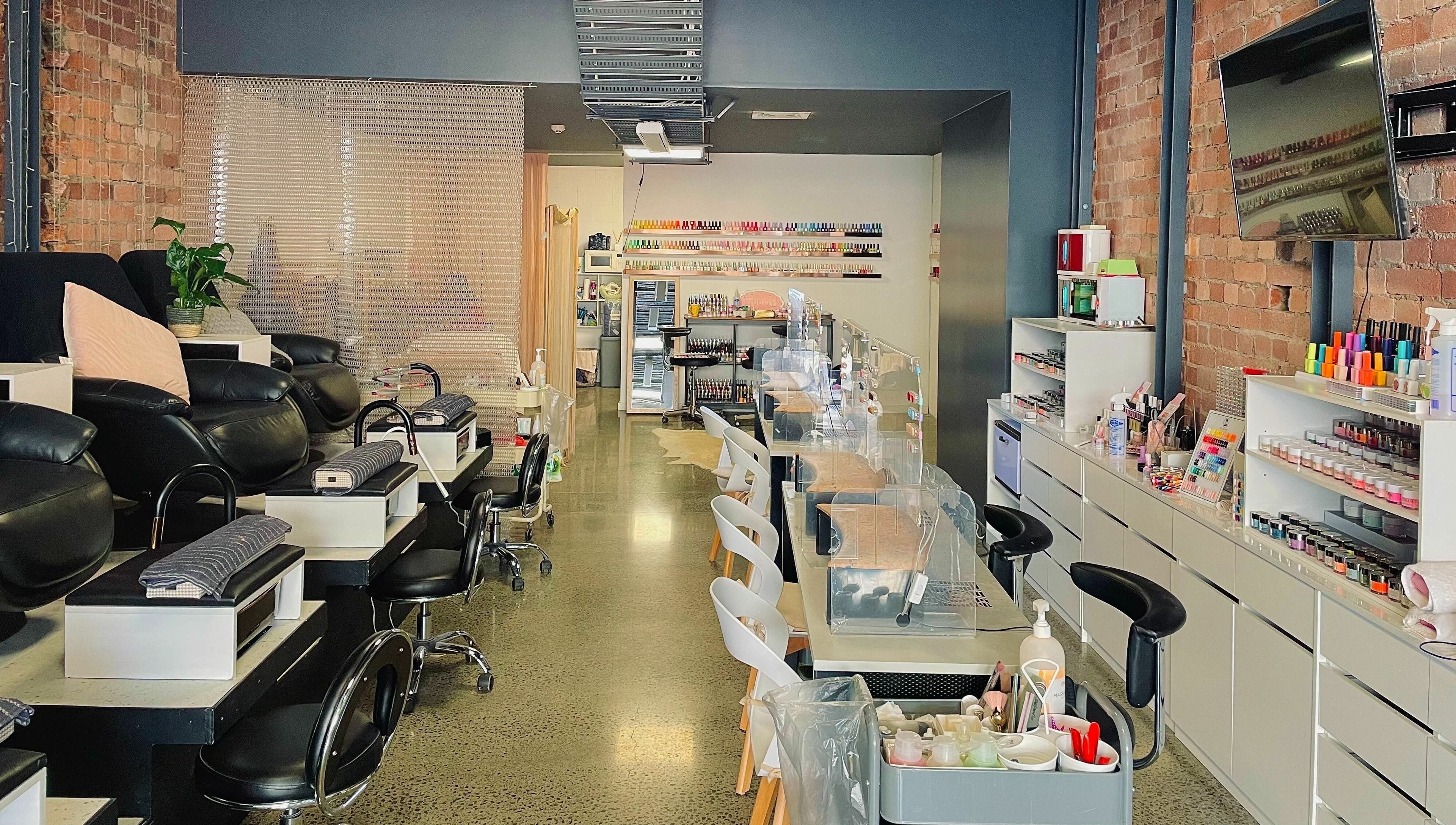 Modern nail salon interior at Studio V in Lower Hutt, Wellington, NZ, showcasing plush seating and vibrant colors.