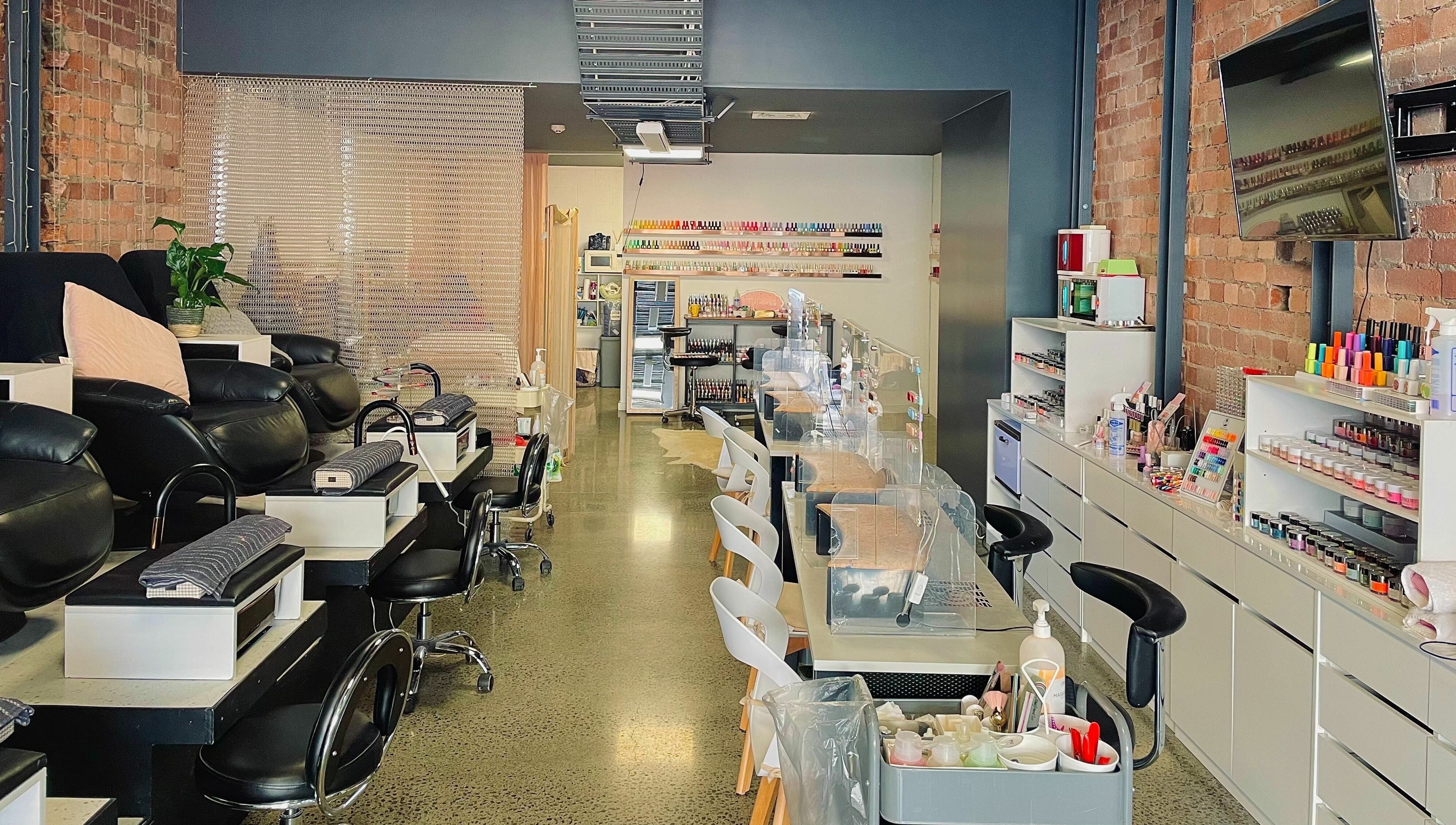 Modern nail salon interior at Studio V in Lower Hutt, Wellington, NZ, showcasing plush seating and vibrant colors.