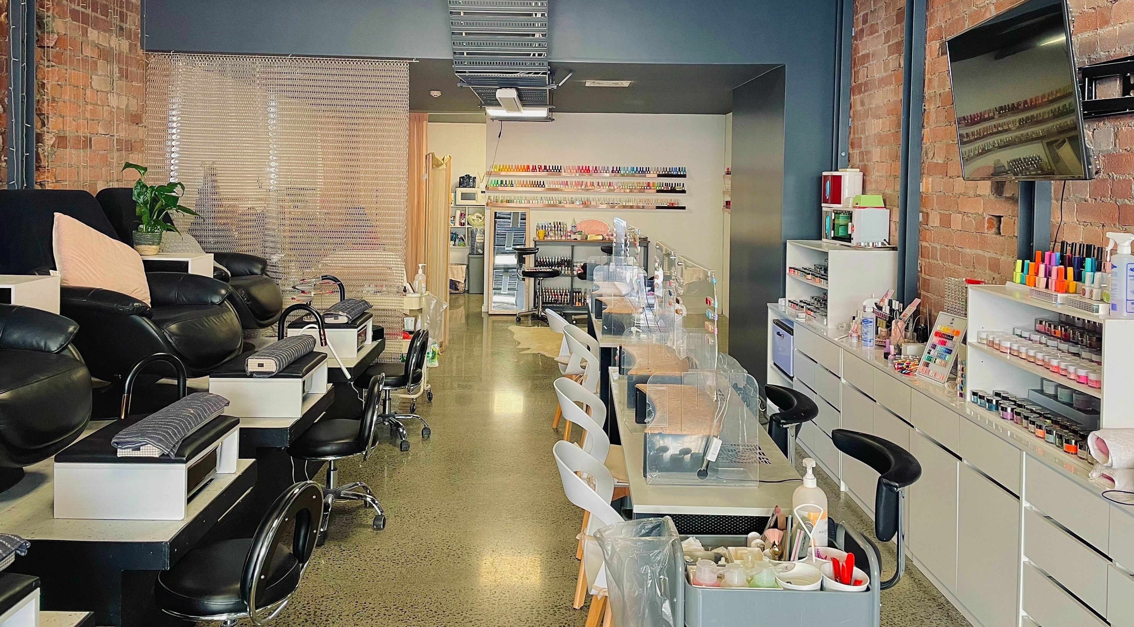 Modern nail salon interior at Studio V in Lower Hutt, Wellington, NZ, showcasing plush seating and vibrant colors.