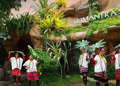 Traditional dancers greet guests at Srimantra Spa in Chang Wat Chiang Mai, TH, surrounded by lush greenery.