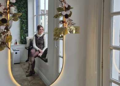 Chic interior with a mirror and a seated guest at Hair By Helena, Nantwich, England, GB.