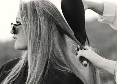 Hair stylist blow-drying hair at The Beauty Loft in Marmora, Ontario, CA.