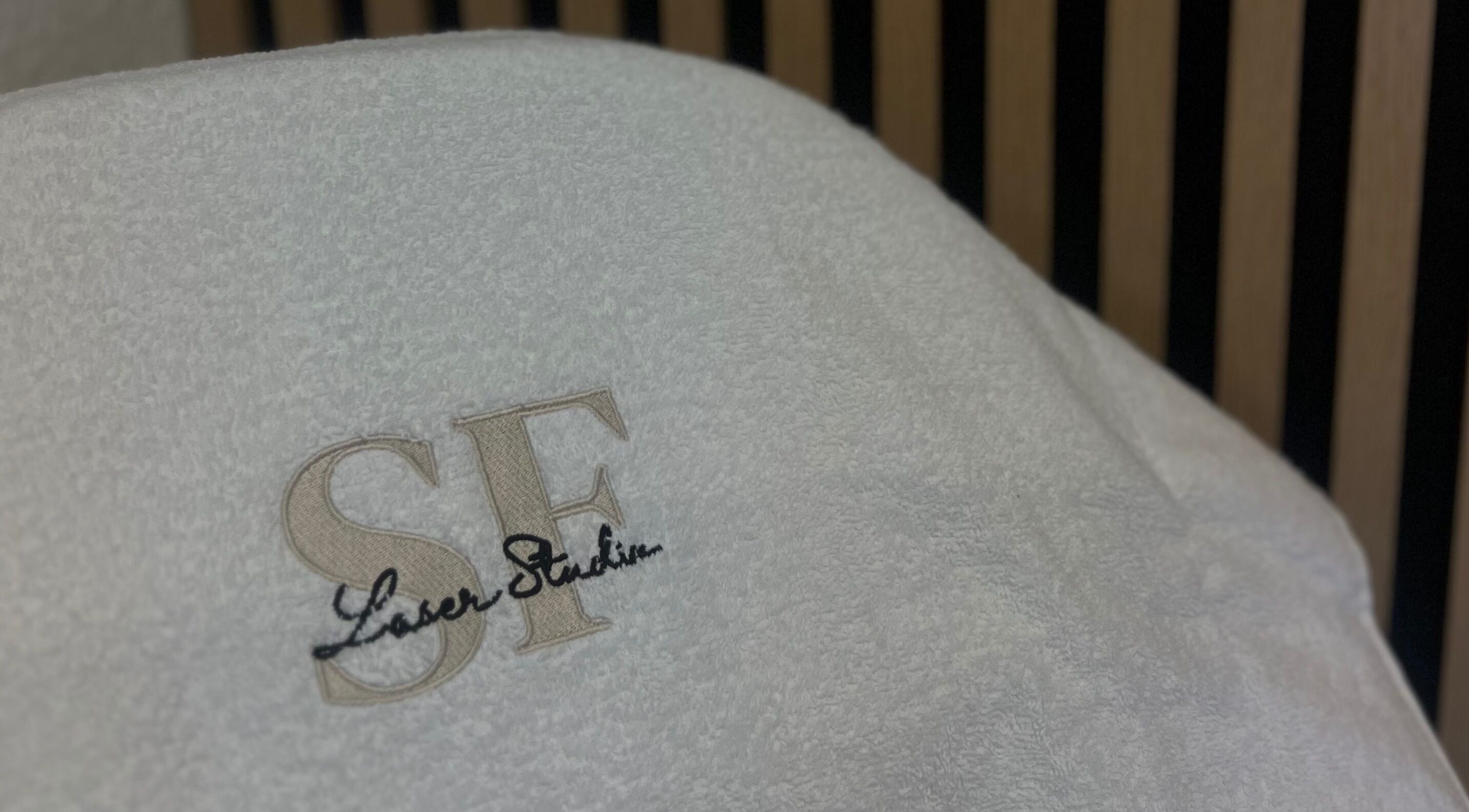 Embroidered SF Laser Studio towel at Dereham, England, GB highlighting luxury spa service.