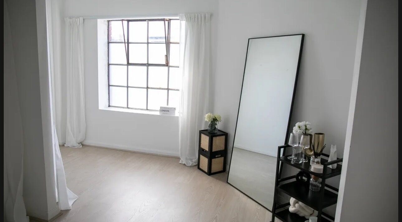 Minimalist room at Bliss Skin and Beauty, Bristol, England, GB with a large mirror and natural light.