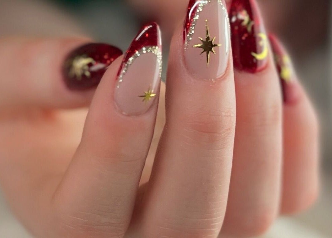 Elegant red and gold star-themed nail art available at Nails and Tails, Clevedon, England, GB.
