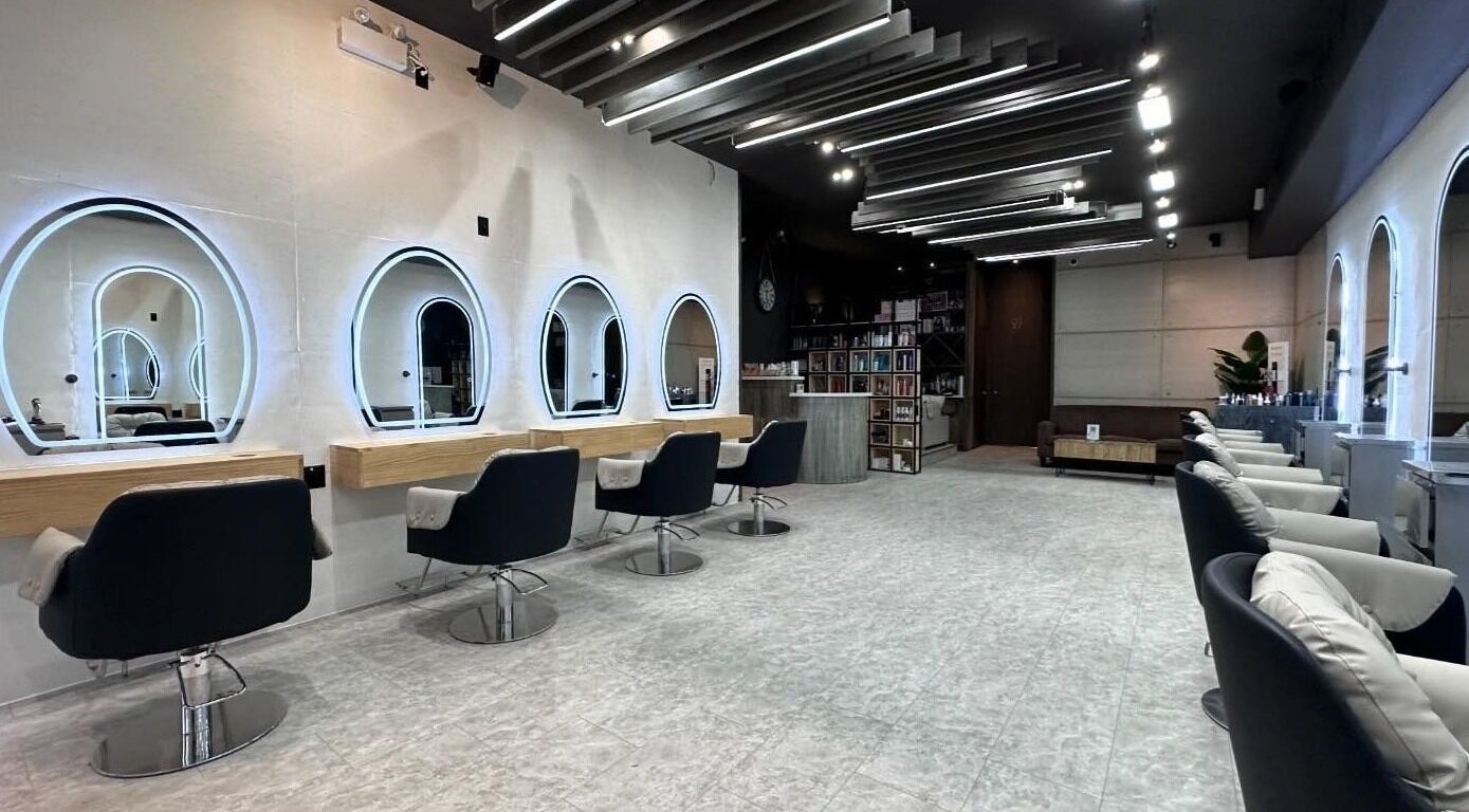 Modern salon interior at STAGE HAIR DESIGN in Toronto, Ontario, CA featuring stylish seating and illuminated mirrors.