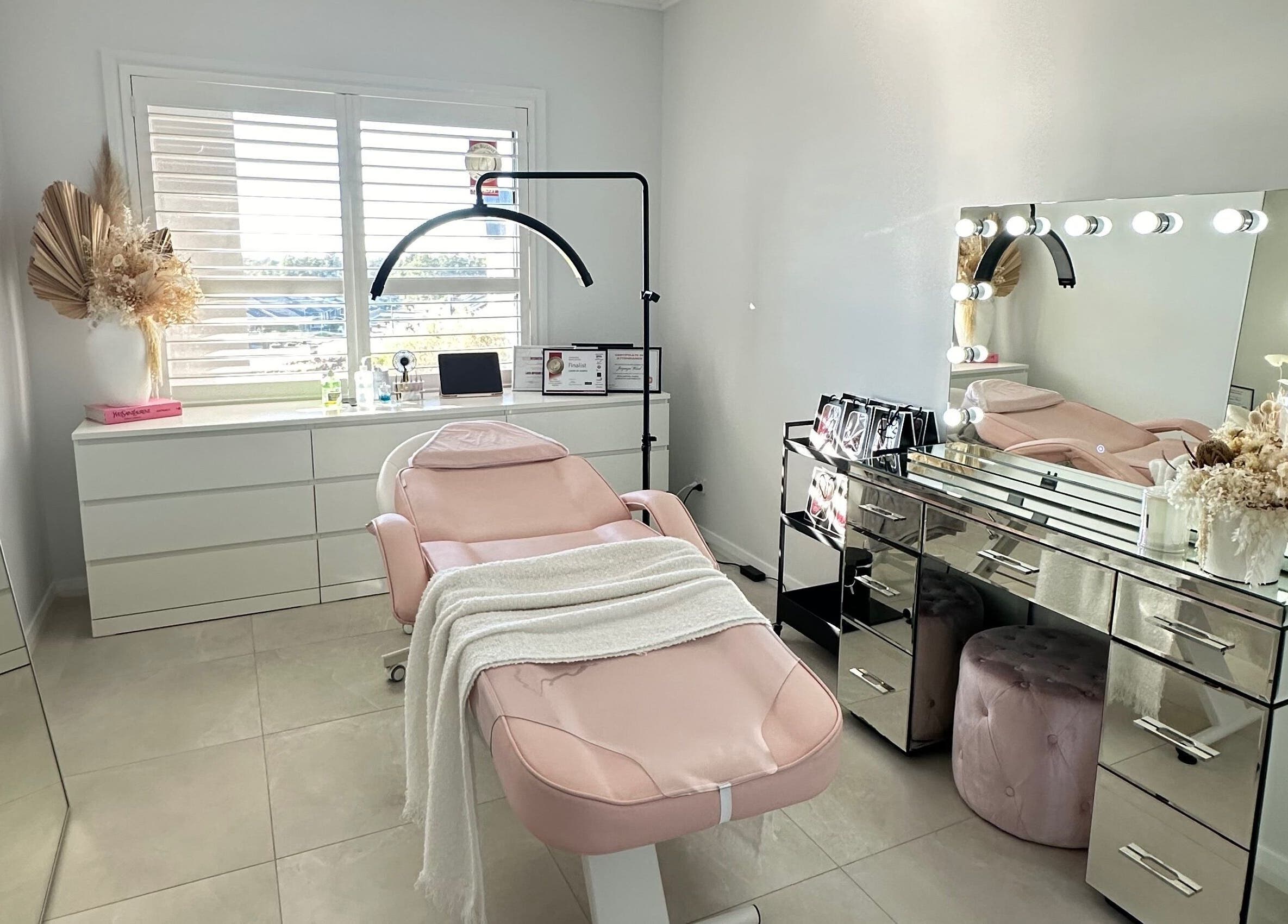 Chic beauty room at Lashes By Jazmyn, Silverdale, New South Wales, AU with a plush pink chair and vanity mirror lights.