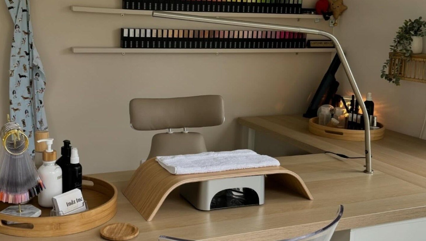 Clean, inviting nail station at Indz Inc, Altrincham, England. Features tidy work surface with beauty supplies.