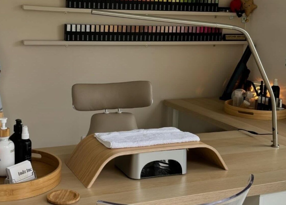 Clean, inviting nail station at Indz Inc, Altrincham, England. Features tidy work surface with beauty supplies.