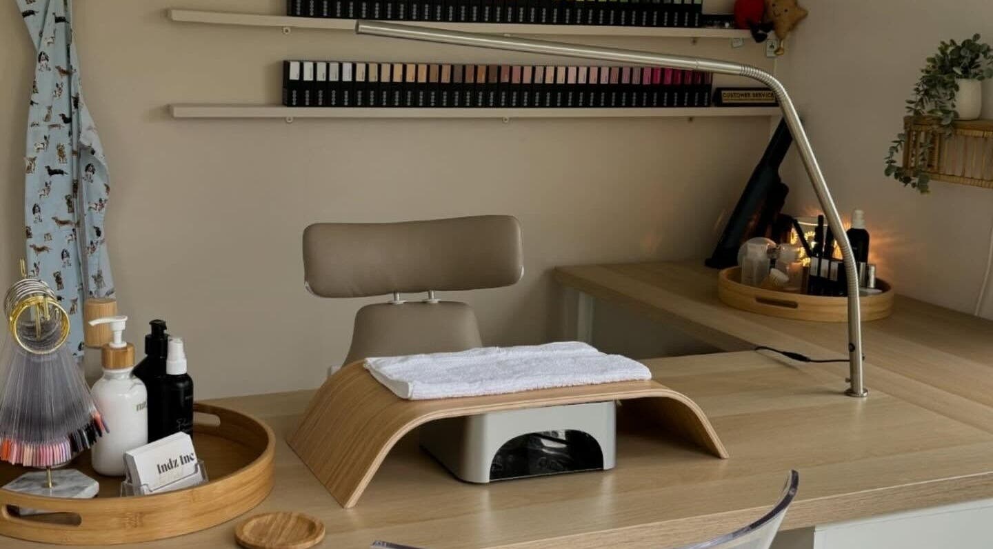 Clean, inviting nail station at Indz Inc, Altrincham, England. Features tidy work surface with beauty supplies.