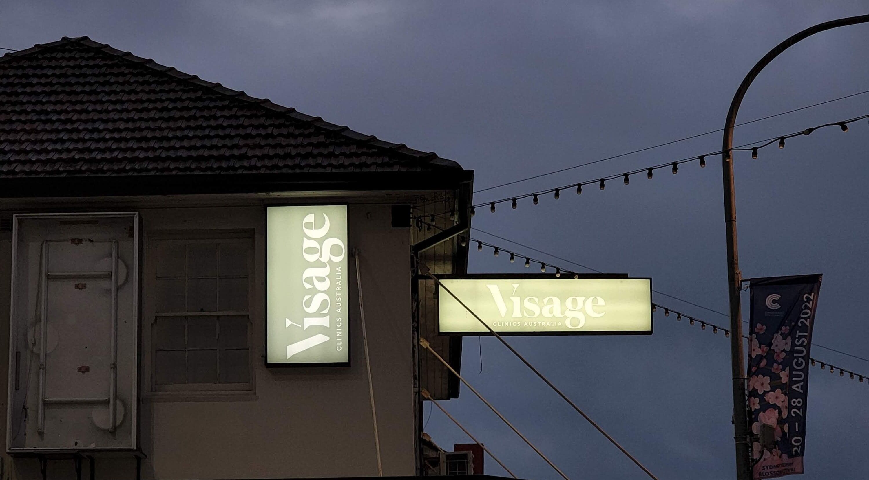 Visage Clinics Australia sign illuminated at night in Merrylands, New South Wales, AU.