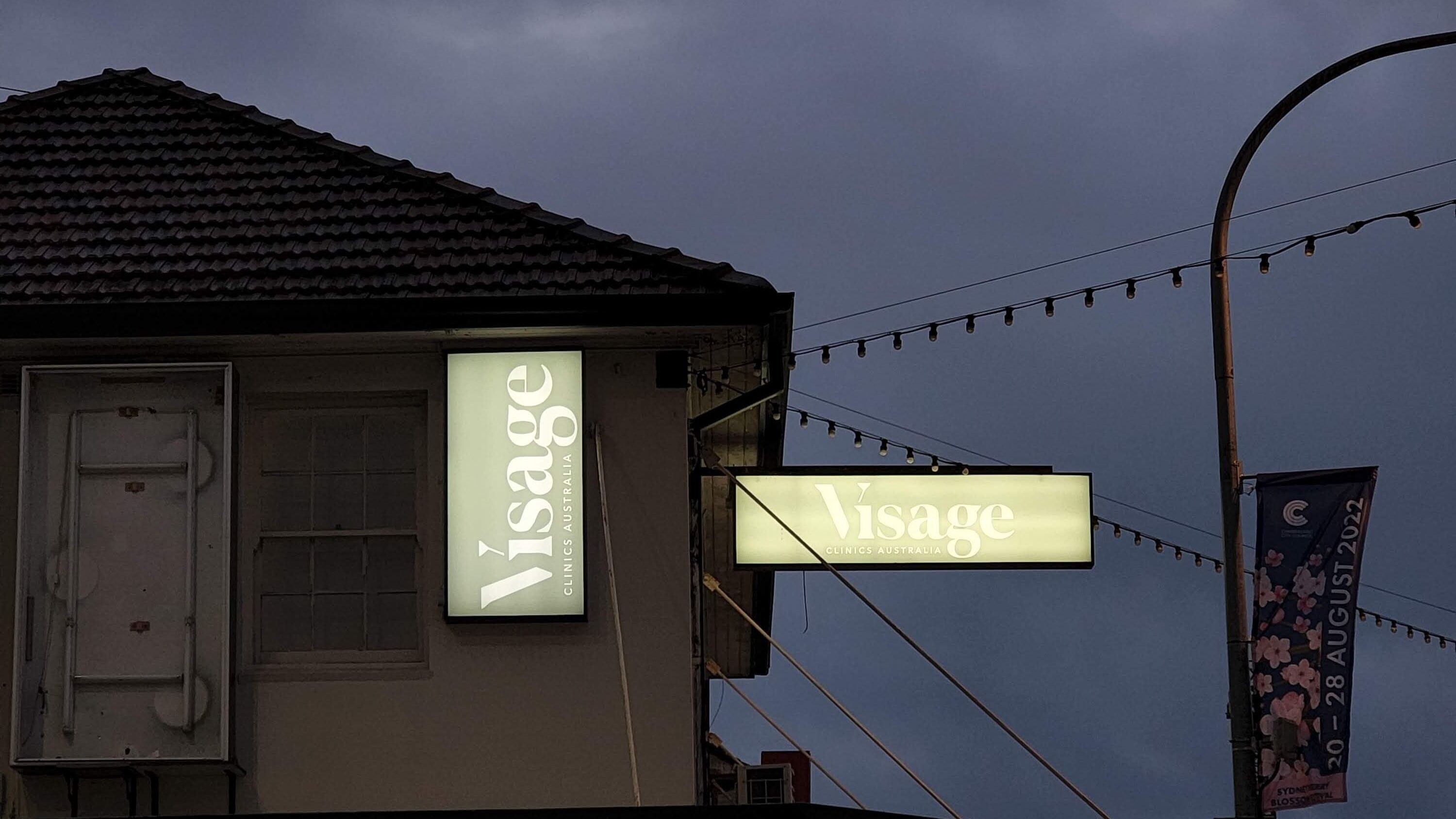 Visage Clinics Australia sign illuminated at night in Merrylands, New South Wales, AU.