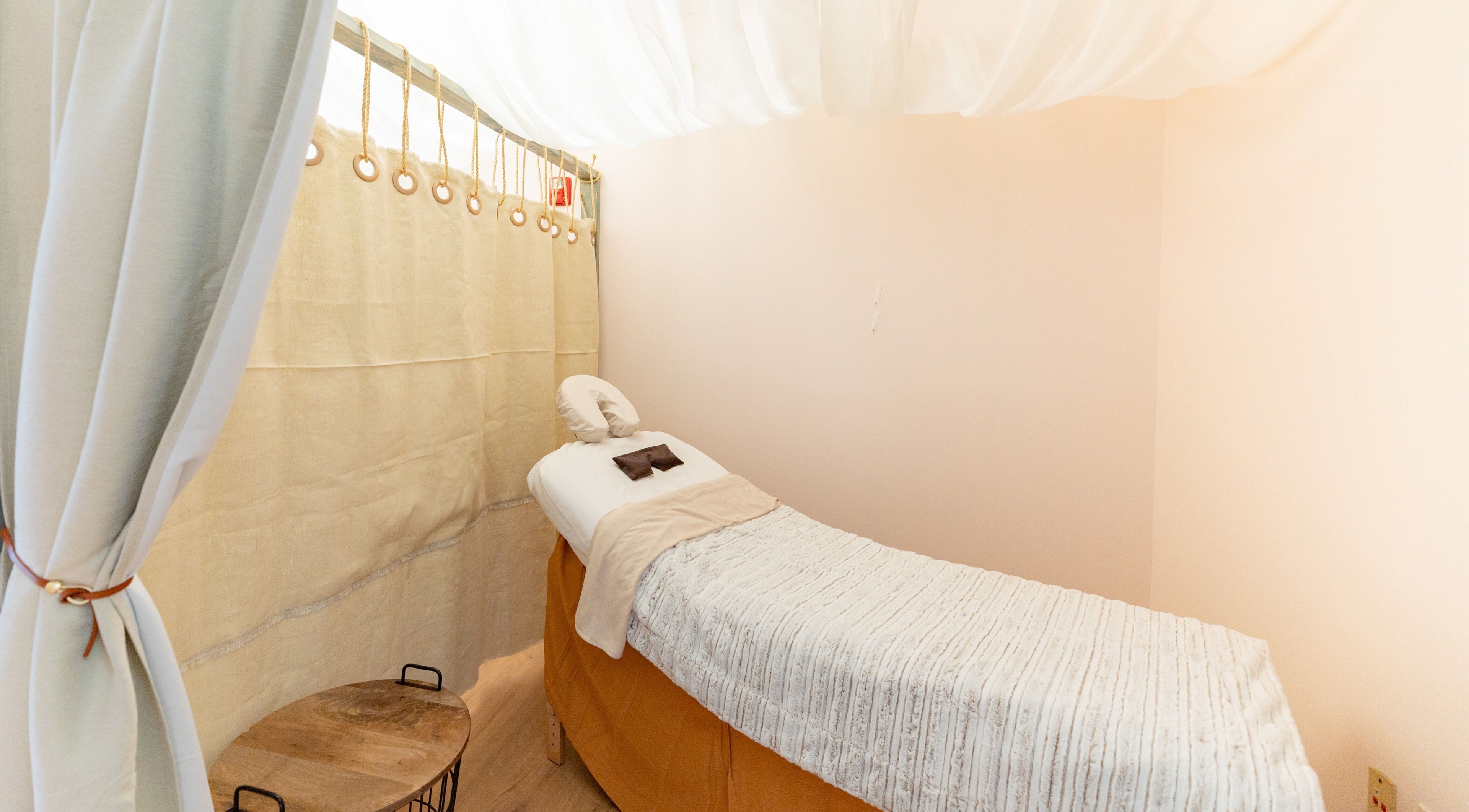 Tranquil massage room at Bliss Spa and Wellness, Centennial, Colorado, US with soft drapes and cozy table.