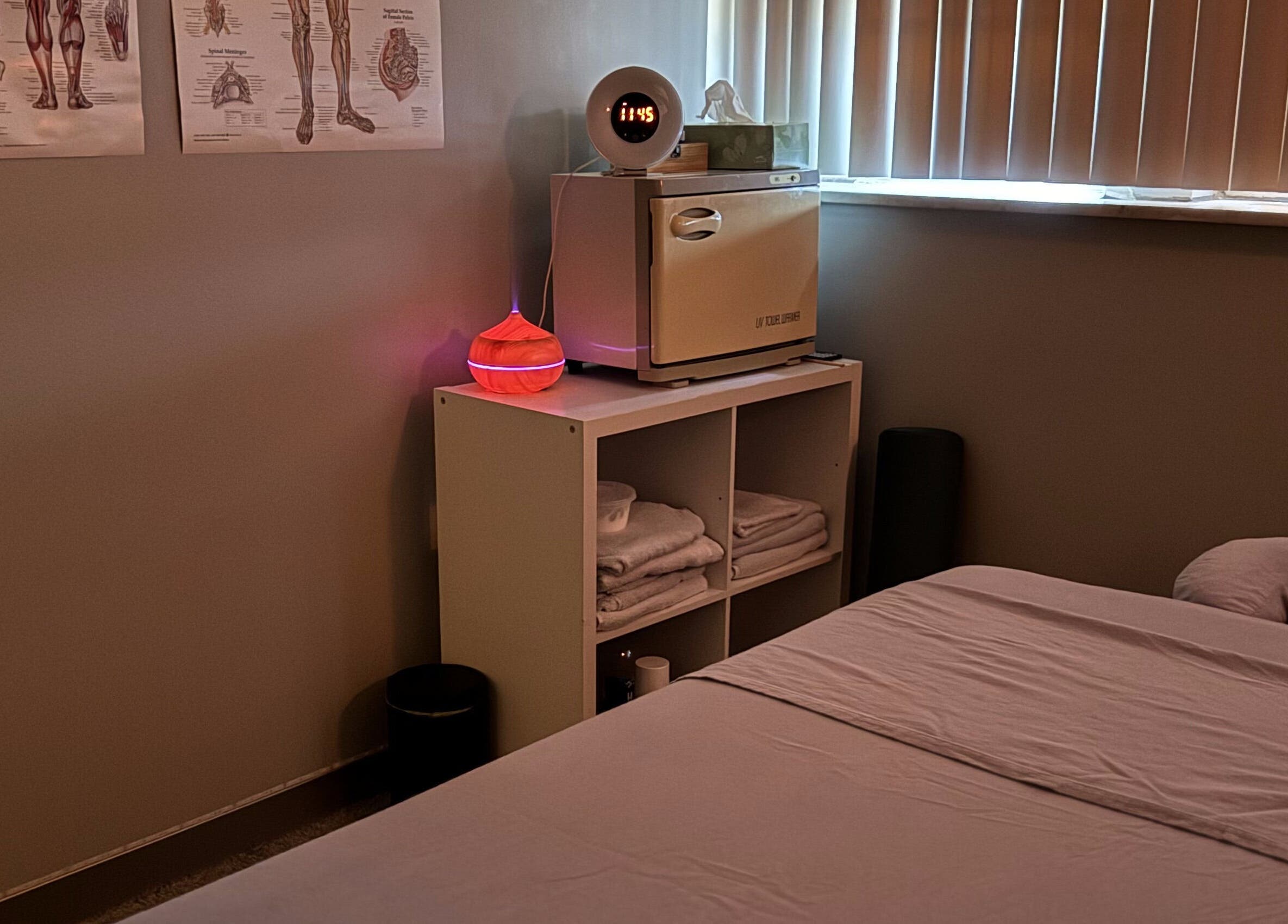 Relaxing massage room at Wellness in Harmony Massage & Sound, Des Plaines, Illinois, US, featuring a bed and warm lighting.