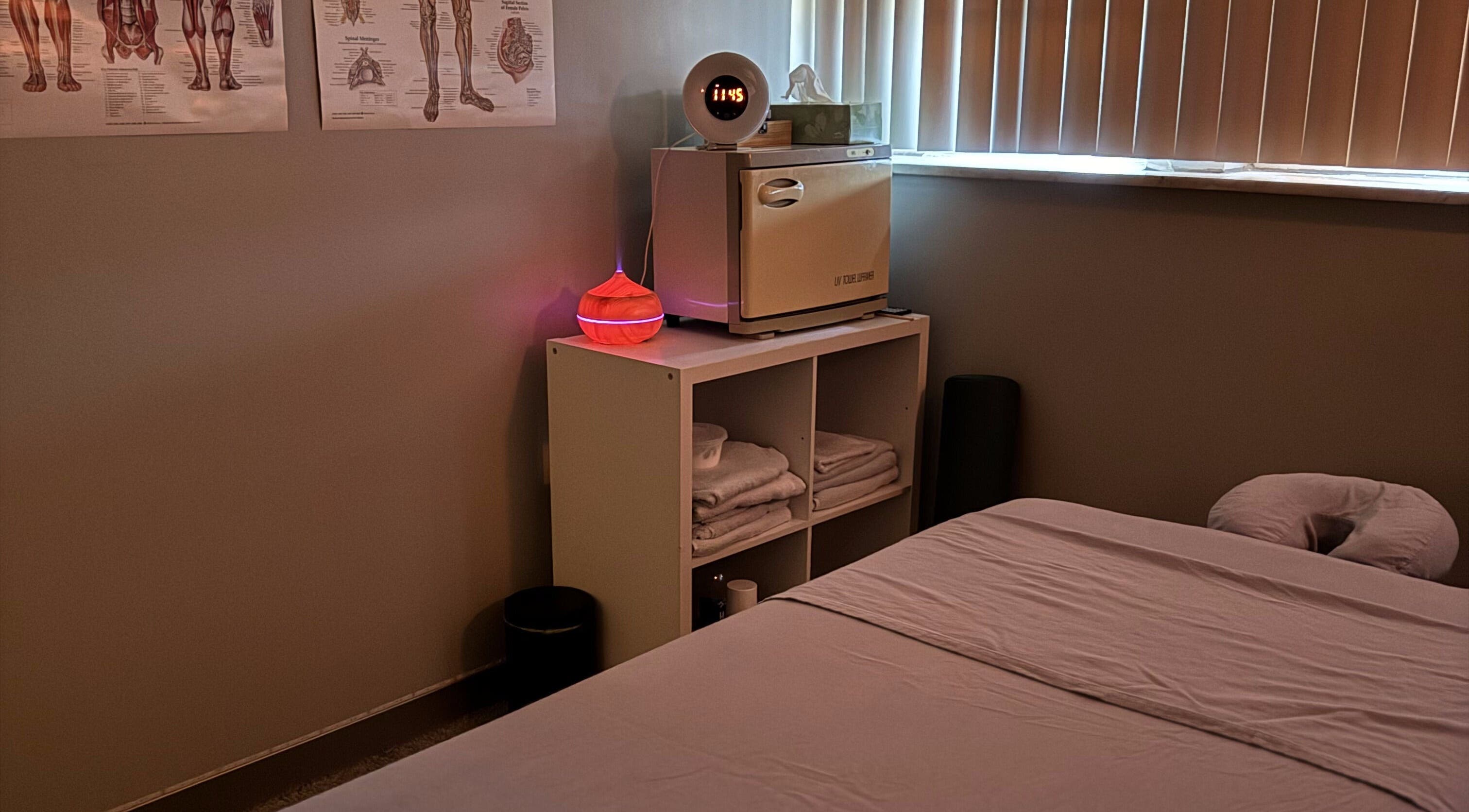 Relaxing massage room at Wellness in Harmony Massage & Sound, Des Plaines, Illinois, US, featuring a bed and warm lighting.