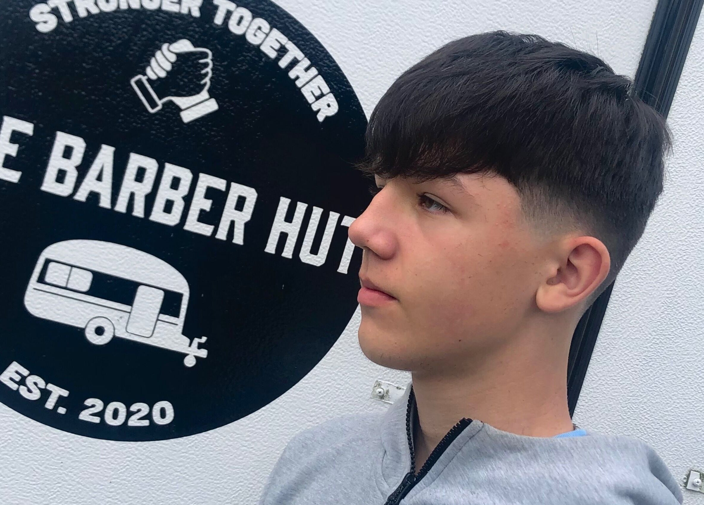 Youth showcasing fresh haircut at The Barber Hut, Portrush, Northern Ireland, GB. Modern and stylish venue.