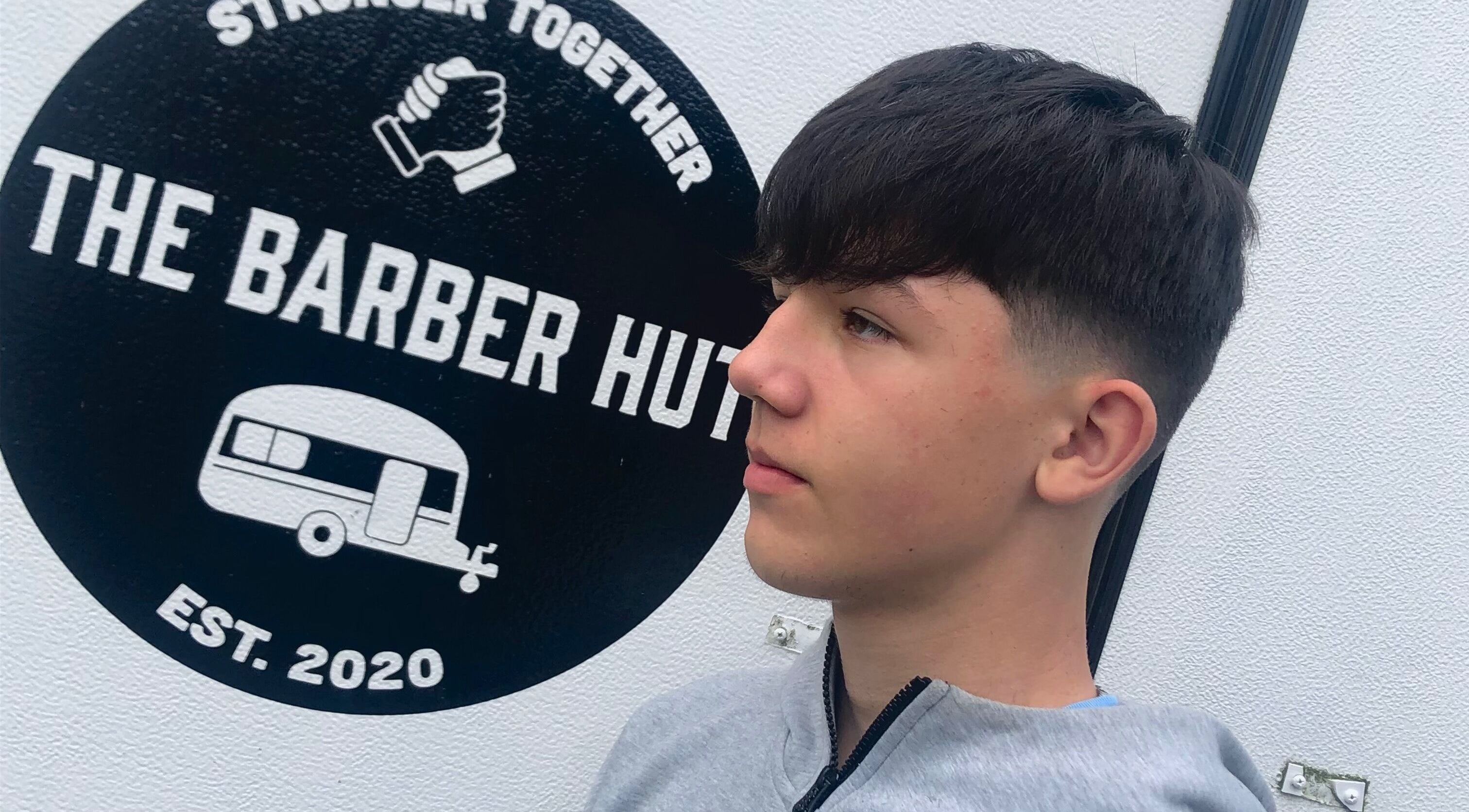 Youth showcasing fresh haircut at The Barber Hut, Portrush, Northern Ireland, GB. Modern and stylish venue.