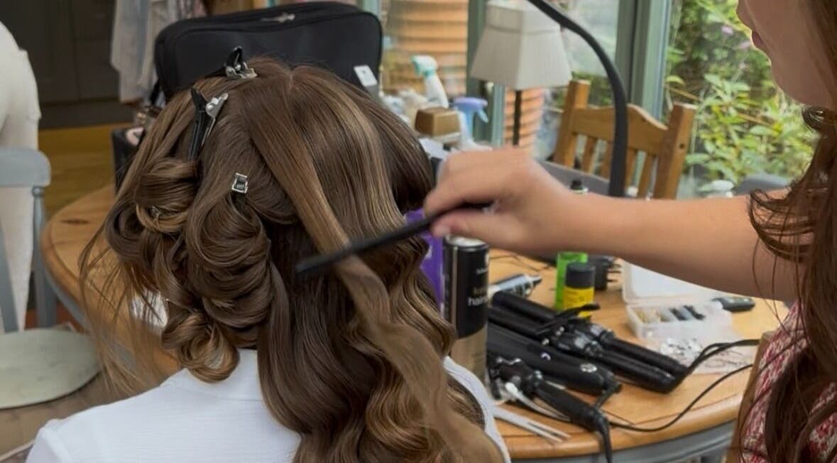 A stylist curling hair in Femme Fatale Hair Portsmouth, Portsmouth, England, GB.