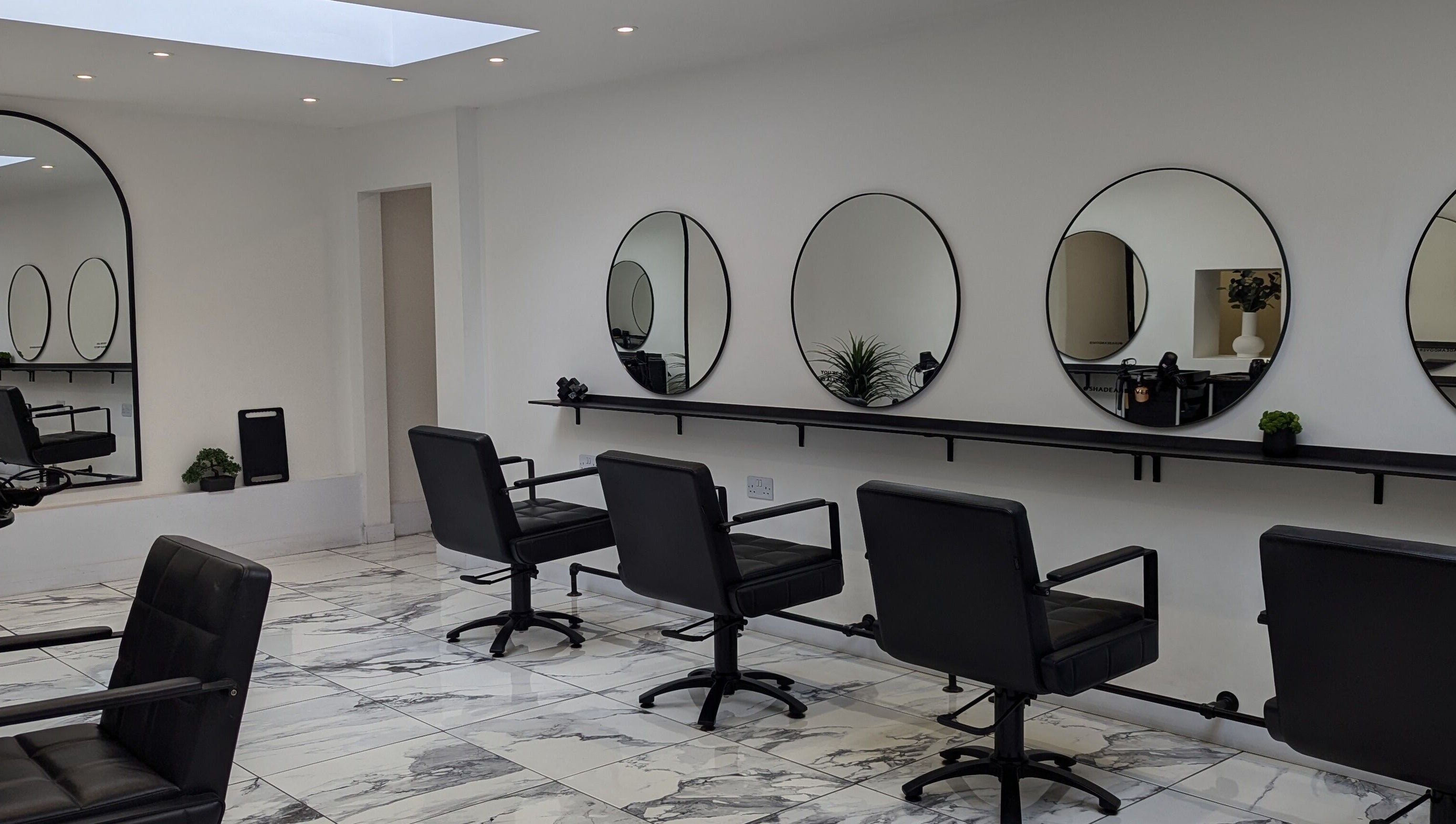 Modern salon interior at Vikki Crocker Hairdressing in Andover, England, GB with chic mirrors and styling chairs.