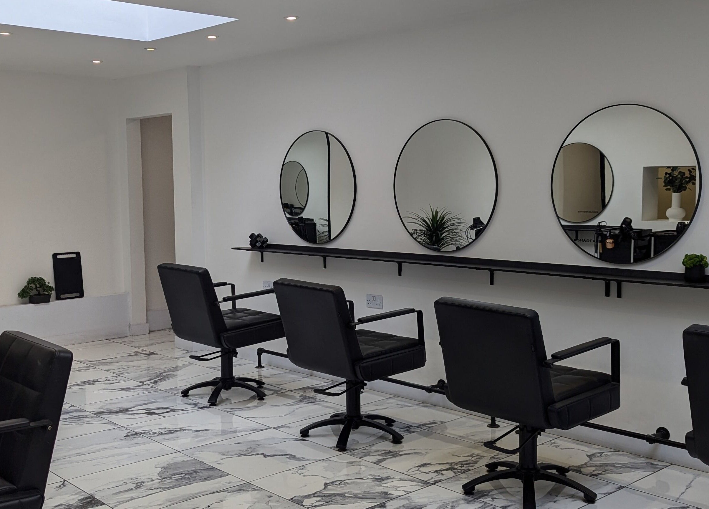 Modern salon interior at Vikki Crocker Hairdressing in Andover, England, GB with chic mirrors and styling chairs.