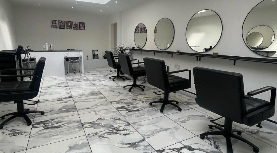 Elegant interior of Lauren Pomphrey Hairdressing in Andover, England showcasing sleek styling chairs and mirrors.