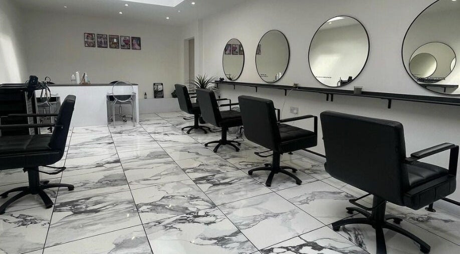 Elegant interior of Lauren Pomphrey Hairdressing in Andover, England showcasing sleek styling chairs and mirrors.