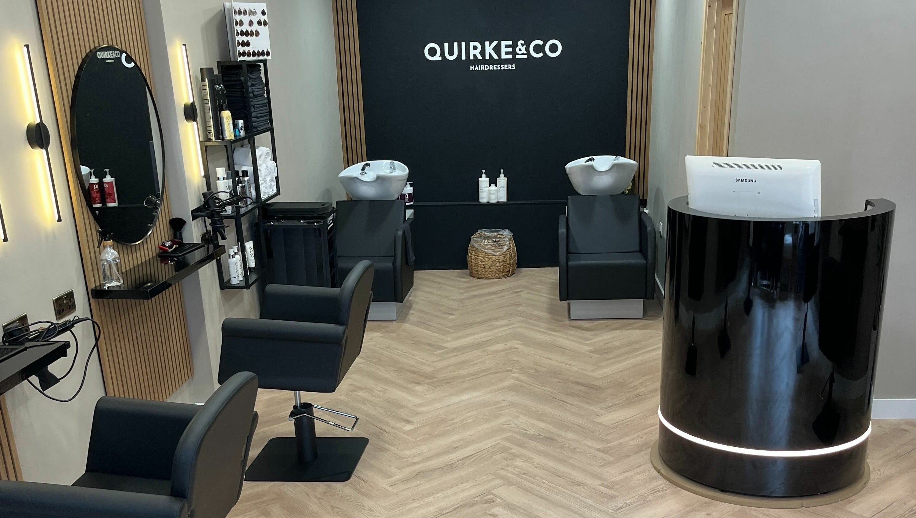 Interior of Quirke & Co Hairdressers in Pontypridd, Wales, GB showing modern salon chairs and wash stations.