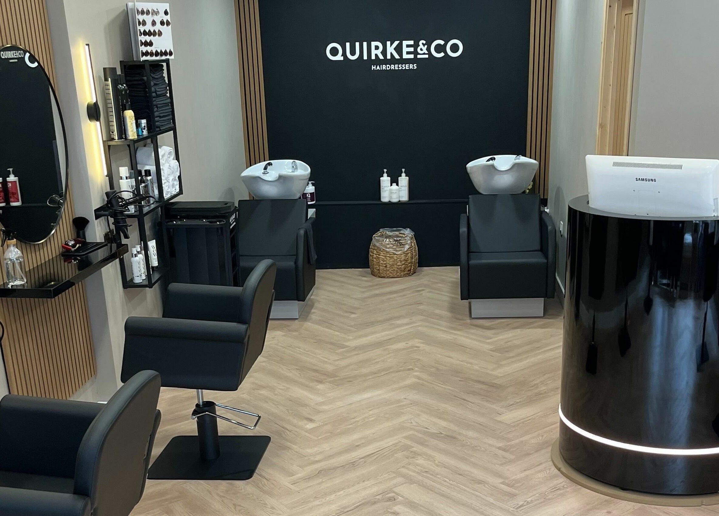 Interior of Quirke & Co Hairdressers in Pontypridd, Wales, GB showing modern salon chairs and wash stations.