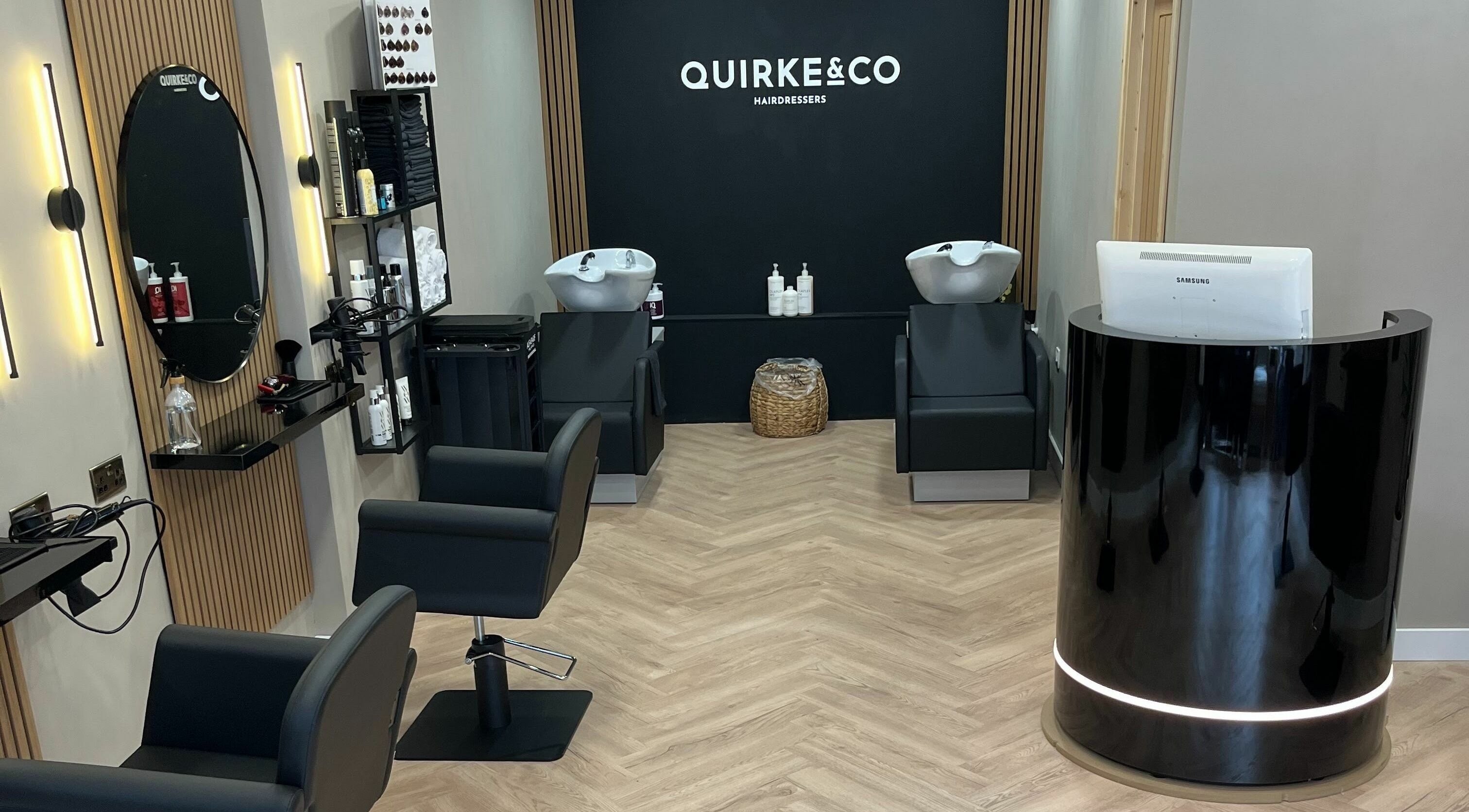 Interior of Quirke & Co Hairdressers in Pontypridd, Wales, GB showing modern salon chairs and wash stations.