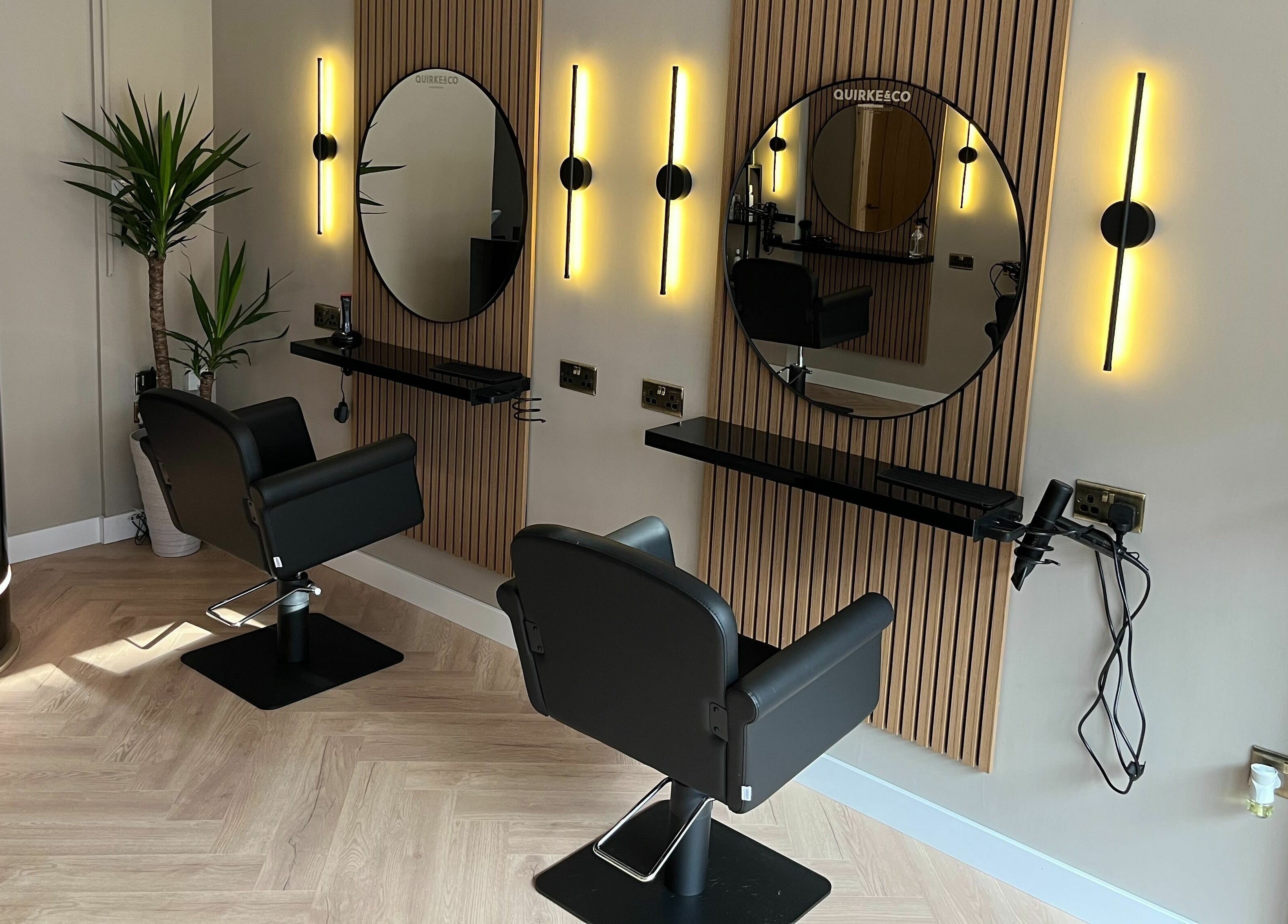 Modern salon chairs and mirrors at Quirke & Co Hairdressers, Pontypridd, Wales, GB, reflecting chic elegance.