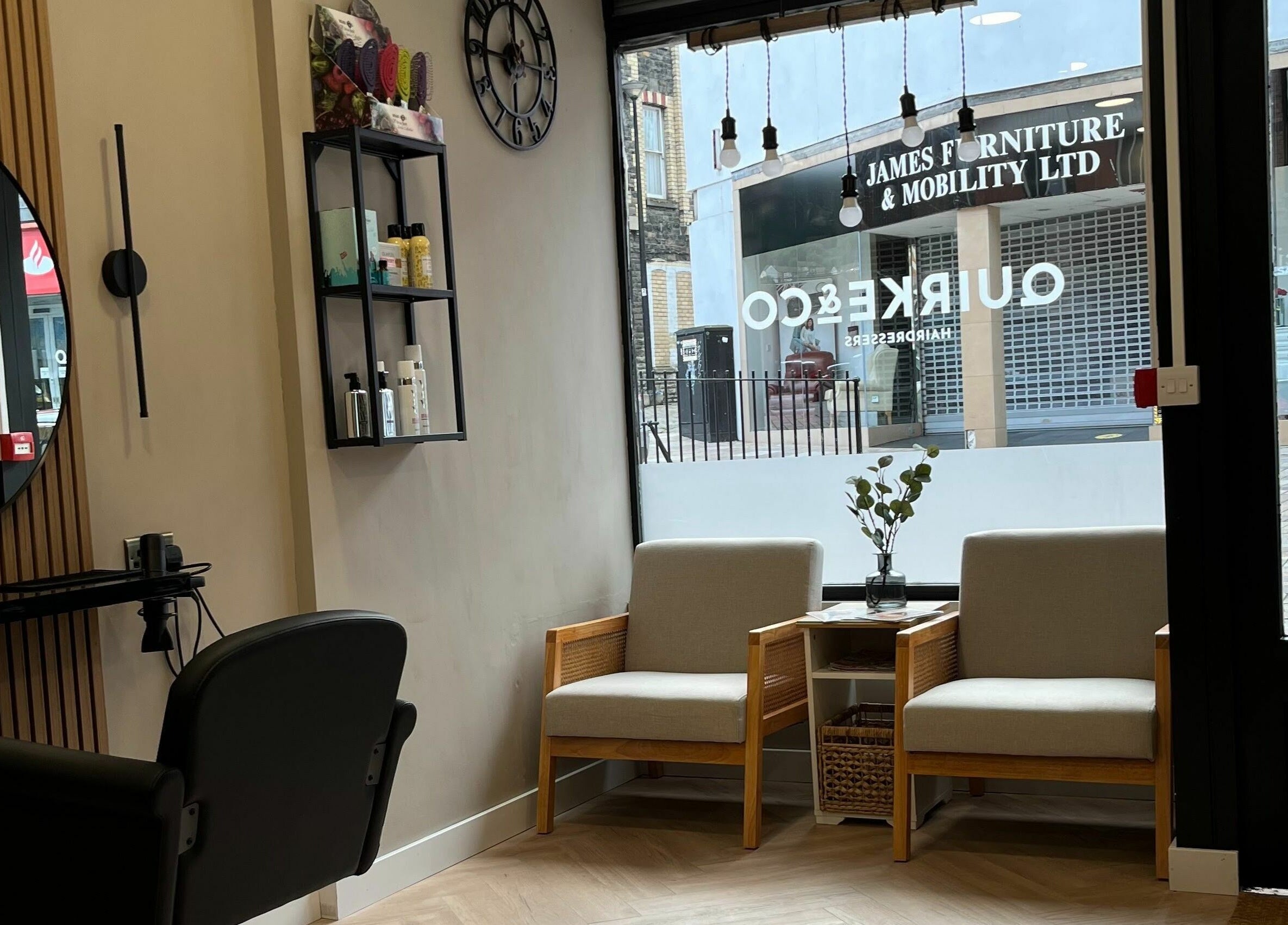 Interior of Quirke & Co Hairdresseres in Pontypridd, Wales, GB featuring modern seating and hairdressing station.