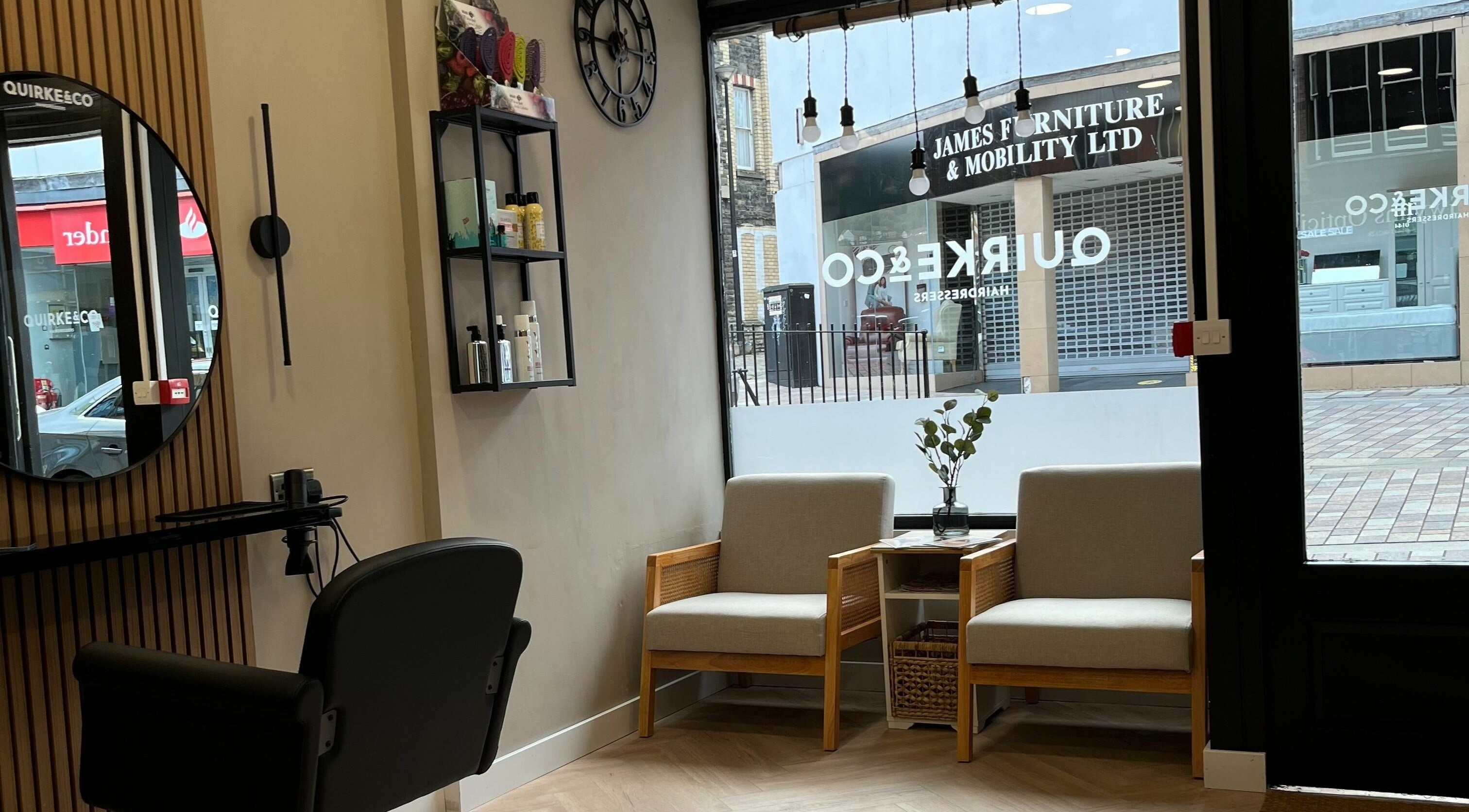 Interior of Quirke & Co Hairdresseres in Pontypridd, Wales, GB featuring modern seating and hairdressing station.