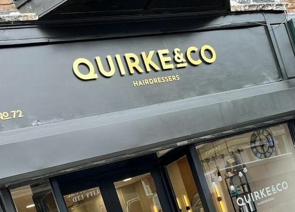 Front entrance of Quirke & Co Hairdressers in Pontypridd, Wales, GB with stylish signage.
