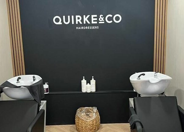 Modern wash stations at Quirke & Co Hairdressers in Pontypridd, Wales, GB with sleek black chairs.