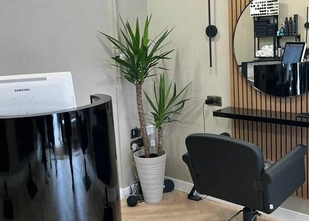 Modern salon setup at Quirke & Co Hairdressers in Pontypridd, Wales, GB featuring sleek chair and mirror.