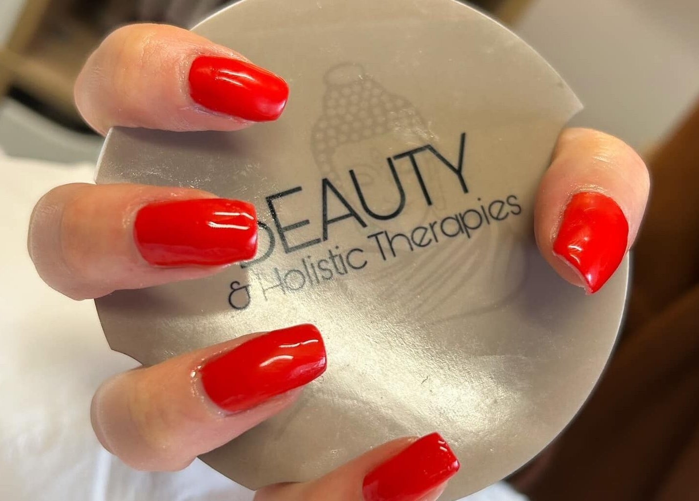 Bright red nails at Beauty & Holistic Therapy, Thornaby, England, GB with logo in background.