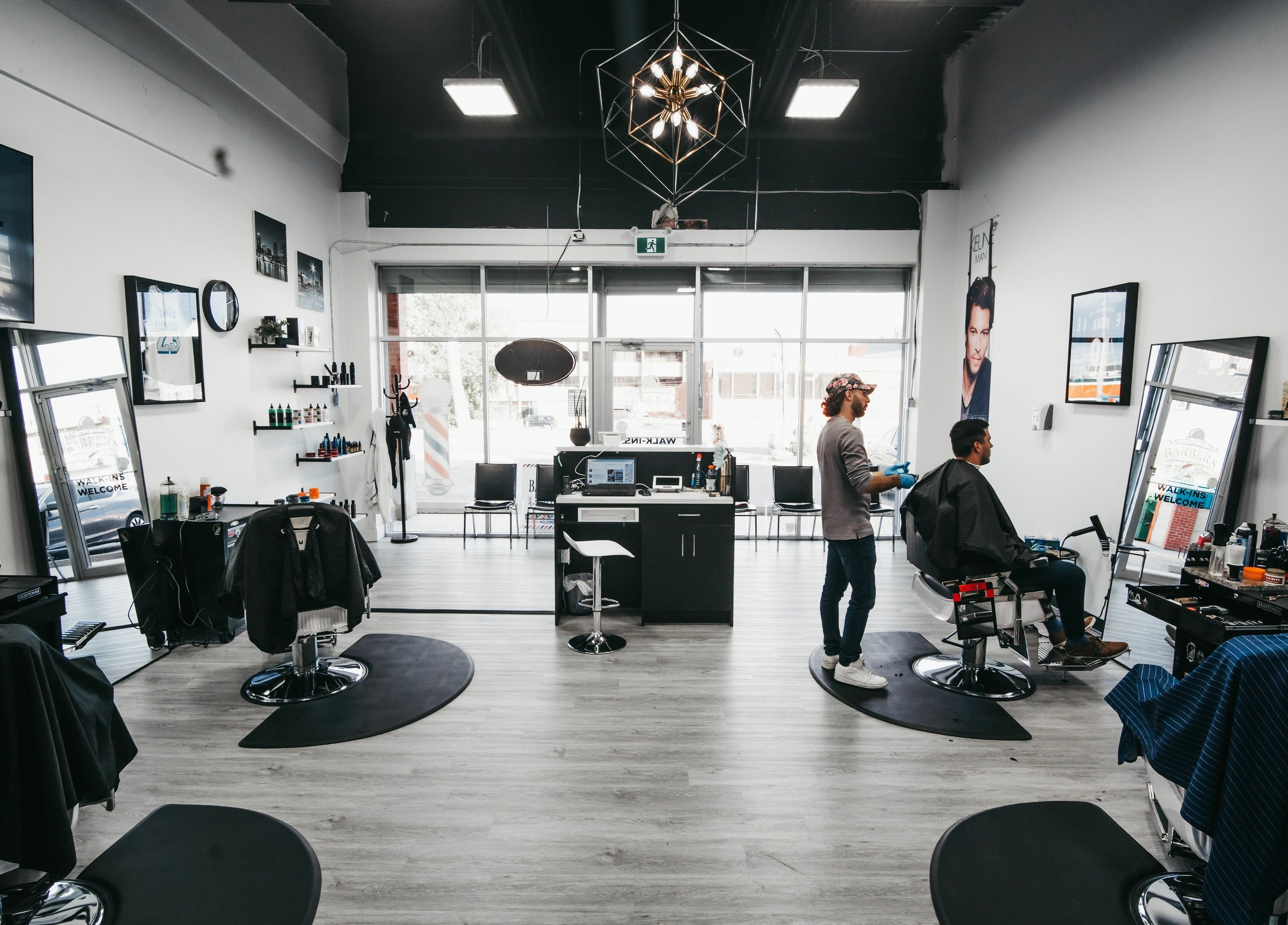 Interior of Macleod Trail Barbers in Calgary, Alberta, CA, featuring modern decor and barbers attending clients.